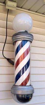 An old fashioned barber pole spins in front of John's Barber Shop
