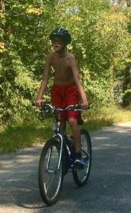 Jackson Choma, a fifth- grader at The Stillwater School, finishes the bike portion.