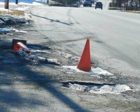 A traffic cone sits frozen in one of the now 8-inch-deep potholes at the intersection of Forest Lakes Drive and Rt. 206 in Andover Borough on Wednesday, Jan 22, 2020.