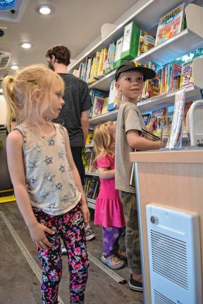 New mobile library launched <b>Joni Clawson, 5, of Sandyston</b> with her brother Leo, 8, and sister Mavis, 2, look at books in the new mobile library, Dot, on Wednesday, June 18. (Photos by Theresa Esposito)