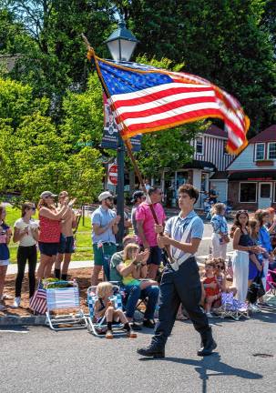 Sparta. Fourth of July events A member of the Sparta Ambulance Squad carries a flag in the parade.