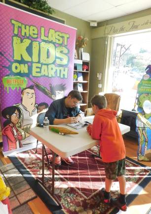 Kids 'touch zombies' and play Mad Libs with author Max Ballier at Sparta Books Max Brallier, author of the popular Last Kids on Earth series, signs a book for a young fan at Sparta Books on Tuesday, Sept. 17, 2019. The latest book in the series, The Last Kids on Earth and the Midnight Blade, was released that day, as well as the series premiere of a Netflix show based on the books.