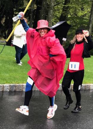 Runners and walkers enjoy Rev It Up 5K and 10K Rain, schmain! Michele Dunn and Diana Byrne enjoyed making the most of the day with umbrellas, panchos, and heart-felt smiles. (Photo courtesy of Tara Hagen)