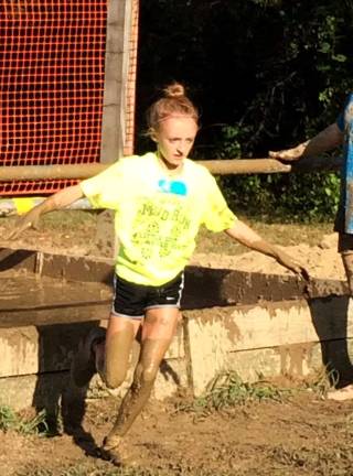 Getting dirty for a great cause Ashley Smith, of Stillwater, navigates the final obstacle at Sunday's Mud Run