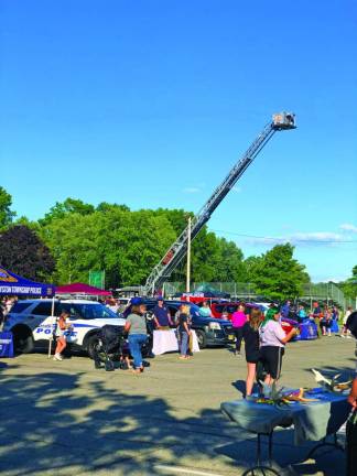 TN2 The extended ladder of a Newton Fire Department truck rises above the National Night Out crowd at Memory Park.