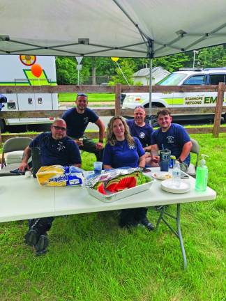 Stanhope-Netcong Ambulance Corps members Benjamin Fontanez, Derek Kuncken, Rebecca Southard, Rich Kuncken and Michael Theriault serve watermelon to the guests.