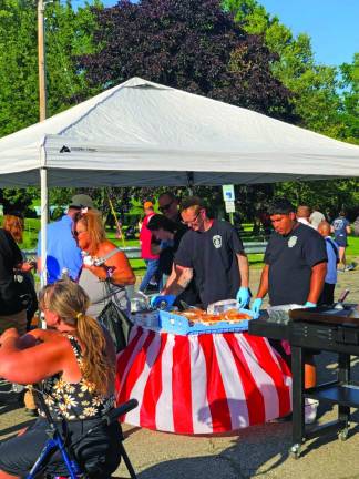 TN4 Members of the Newton Fire Department cook free hot dogs for those attending the National Night Out event.