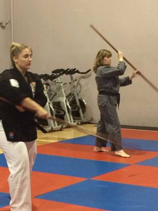 United Martial Arts offers mix of disciplines, dedicated instructors Sensei Lou Popek works with his daughter, Emily, on some Bo exercises.