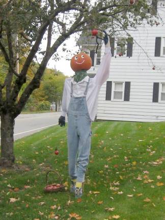 These dashing pumpkin heads await your visit All scarecrow entries must have a real pumpkin head. This entry portrays an autumn country apple picker (Photo by Janet Redyke)