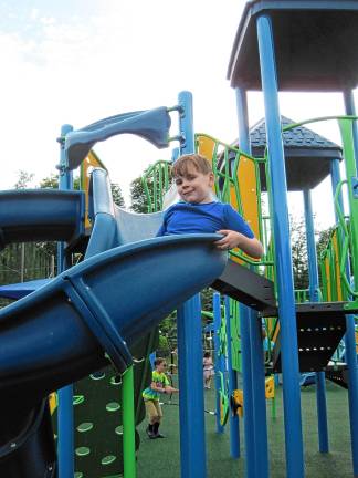 Inclusive playground opens Aidan Heninger-Lowell, 7, goes down the slide at the new completely inclusive playground at C.O. Johnson Park in Byram. (Photo by Theresa Esposito)