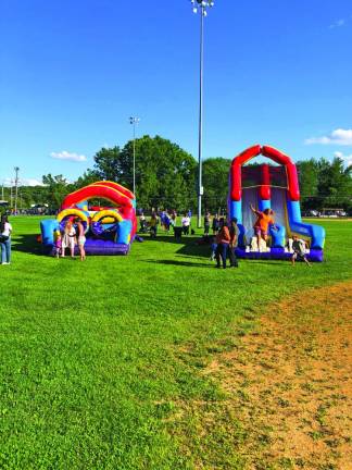 Children climb and slide on inflatable obstacle courses.