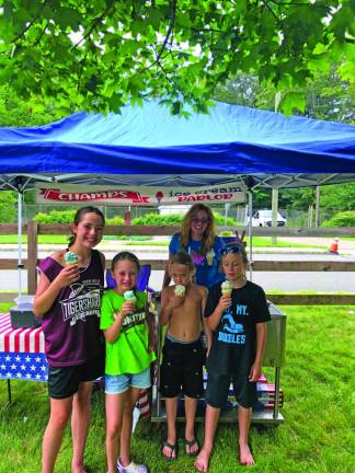 Jeanine Chairis, 12, and her sister Vera, 7, of Stanhope and Declan Tediashvili, 7, and his brother Desmond, 11, of Landing enjoy free ice cream from Stacey Champion of Champs Ice Cream Parlor.