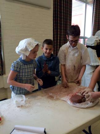 Students bring history alive with Colonial Fair Brick makers Molly Riva, Jackson Choma and Aiden VanHook show off their trade.