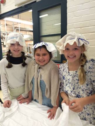 Students bring history alive with Colonial Fair Colonial Bakers pretend to make bread and give out samples at the Colonial Fair.