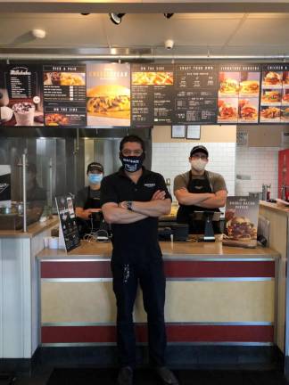 Wayback Burger owner Sushil Bhagudia with employees Brittany Mazzi (left) and Daniel Jabbour (right).