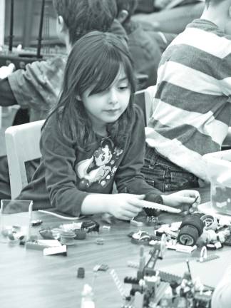 Lego builders start young Abigail Biederman, 5, of Newton looks for bits and pieces to complete her project.
