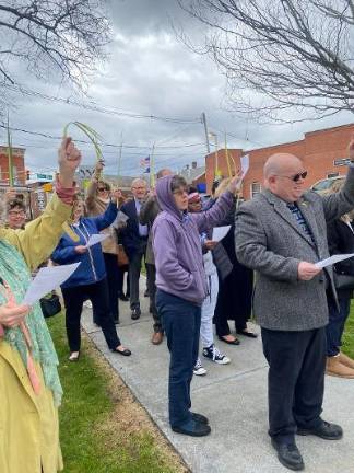 Folks hold up palm fronds during the Liturgy of the Palms on the Newton Square on Sunday.