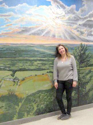 Kim Esposito with her Stairway to Heaven mural, showing a brilliant sunset (Photo by Janet Redyke)