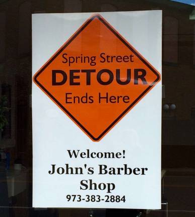 A sign in the window calls people to detour into John's