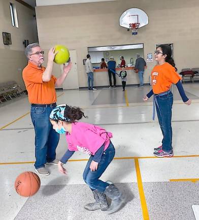From basketball to sock soccer: Outreach Sports gets kids and adults moving Kevin Carr, director of Outreach Sports for Kids, interacts with Annabella and Elora Marquina during the beginning of last Saturday's session (Photo by Laurie Gordon)