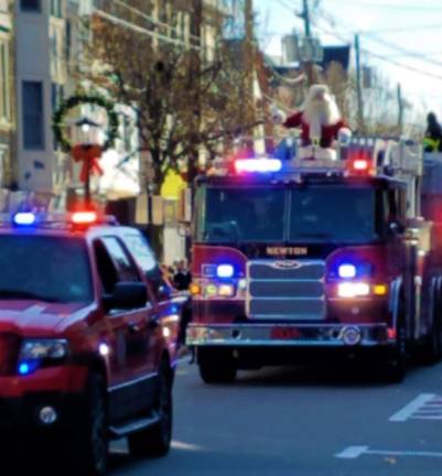 Santa arrives on Spring Street in Newton atop Newton FD Tower 804 during the Annual Holiday Parade on Saturday, Nov 30, 2019.