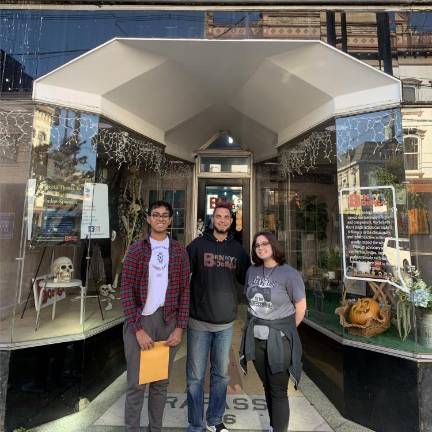 Devon Kumar and DJ Hannon presenting the money they raised through their concerts to Benjamin Davey, co-founder of Benny’s Bodega