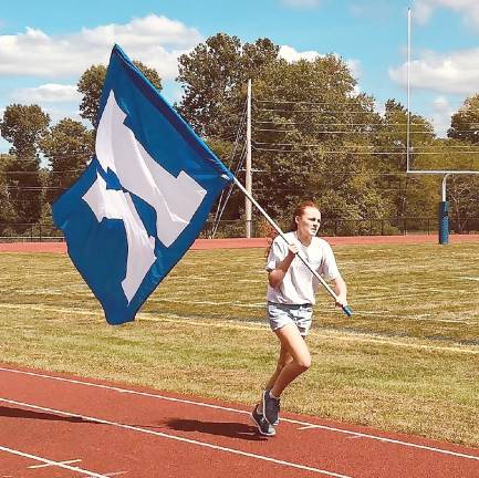 Making noise and wearing blue Brenna Philson completes the all-sport relay for the seventh grade team.