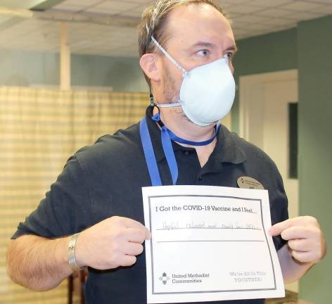 After receiving his first Covid vaccine, Jeffrey Lisk, Bristol Glen’s executive director, displays a comment card with the message, “Hopeful, relieved and ready for 2021!” (Photo by Salvatore Seirmarco)