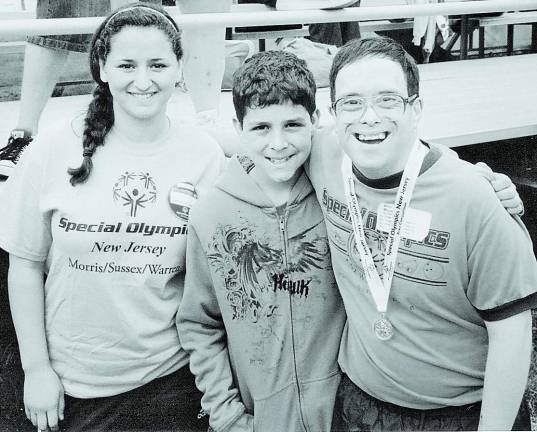 Right on track From left: Special Olympics volunteers Sonia Safarpour of Hackettstown and Henry Morales of Bloomfield congratulate Special Olympics athlete Willie Morales of Hopatcong on his medal-winning performance at the Area 3 Special Olympics Track and Field Meet at Hackettstown High School.
