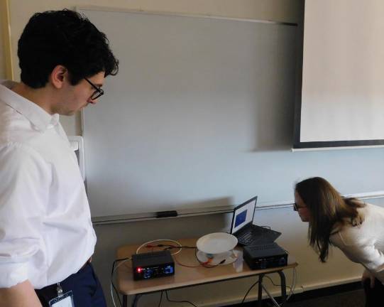 Matthew Richtmyer (L) and Catharine Mack (L), engineers from Johnson &amp; Johnson, demonstrate a working speaker made from paper plates and magnetized coils during the workshop portion of the Women in STEM event at SCCC on Thursday, Jan 9, 2020.