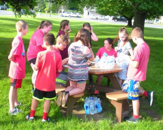 Students from the Long Pond School in Andover enjoy plenty of water and a bagel breakfast on the lawn of the Florence M. Burd Elementary School after the run.