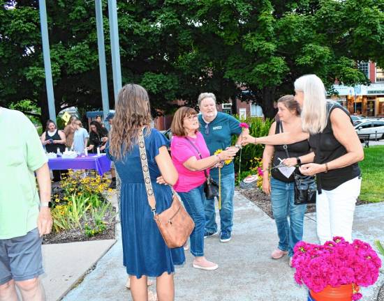 Photos: Overdose Awareness Day Flowers are handed to those attending the Candlelight Vigil and Walk through Remembrance Display sponsored by the Sussex County Recovery Community Center.