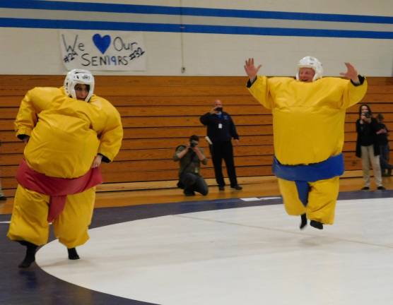 Business teacher and event organizer Theresa Iliff (L) eludes head wrestling coach John Gill during a sumo suit wrestling match, at a fundraiser held at KRHS on Wednesday, May 15, 2019.