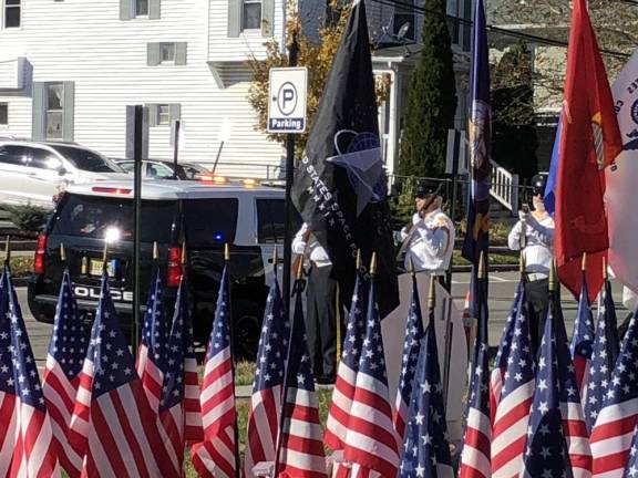 The American Legion Post 86 Honor Guard fires a rifle salute.