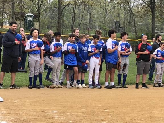 Little League players stand at attention during the national anthem.