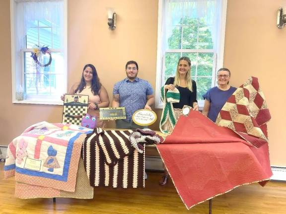 Tranquility UMC members, Emily Delnero, Charlie Giunta, Holly Barry, and Barbara Morgan, stand behind homemade items to be auctioned off.