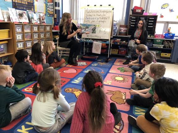 Tara Scrittore, left, reads a story to her kindergarten students at Hamburg School. At right is paraprofessional Enza Ramos. (Photos by Kathy Shwiff)