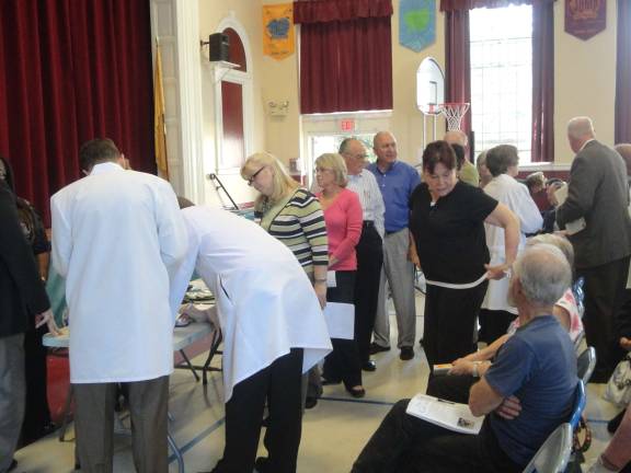 Overflowing crowd voices support for local hospital Guests had to sign in in order to make a three-minute speech about the hospital. Here, the line is already at least a dozen people long a half hour before the hearing started.