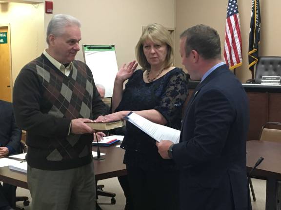 Congressman Josh Gottheimer administers the oath of office to Councilwoman Jean Murphy. Murphy's husband Dan Murphy holds the Bible.