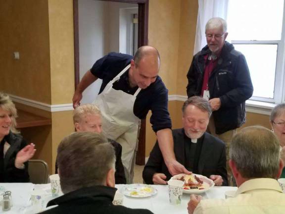 Rev. Robert Griner is served a special breakfast in the form of a cross to kick off the celebration of his 30 years as a priest. PHOTO BY LAURIE GORDON