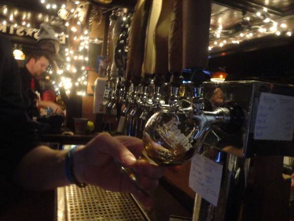 Krogh’s brewery celebrates 15 years with cave-aged brew Photos by Scott Baker Bartender Julian Huarte, of Newton, pours a 15th anniversary Russian imperial stout into a commemorative glass.