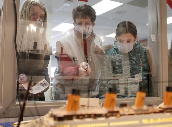 Judith Zoeller, Pope John XXIII Regional High School’s Biondo Research Center media specialist (center) shows artifacts to two middle school students (Photo by Anthony Spaulding, Director of Communications)