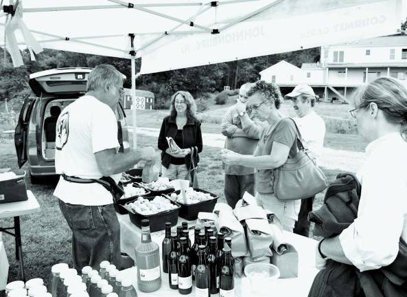 Gobs of garlic At left Roman Osadca owner of Valley Fall Farm tends to customers.