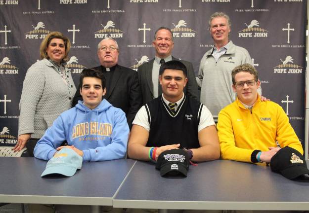 Pope John athletes sign letters of intent (Seated from Left): Pope John seniors Justin Hertlein, Sebastian Flamenco, and Connor Milks signed their National Letter of Intent to continue their academic and football careers at either a NCAA Division I or NCAA Division II school on Wednesday at Pope John XXIII Regional High School. Back row from Left: Athletic Director Mia Gavan, Pope John President Rev. Msgr. Kieran McHugh, Principal Gene Emering, and football head coach Brian Carlson.