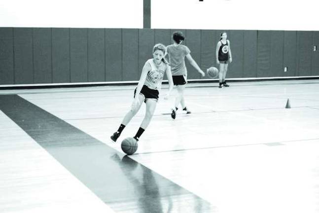 Basketball players learn skills at camp Thirteen-year-old Maddie Leonardi of Newton, NJ reaches for the ball.