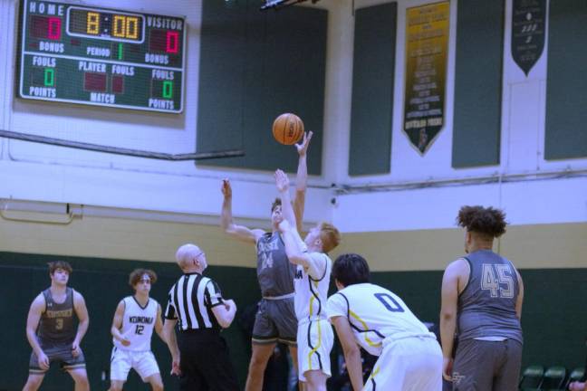 Basketball players during the tip-off to start the game.