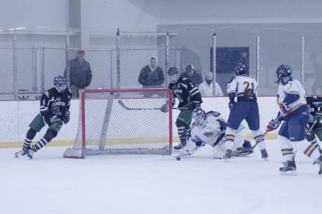 Sparta-Jefferson United goalkeeper Logan Hanek dives towards the ice to intercept the incoming puck in the second period. Hanek made 66 saves.