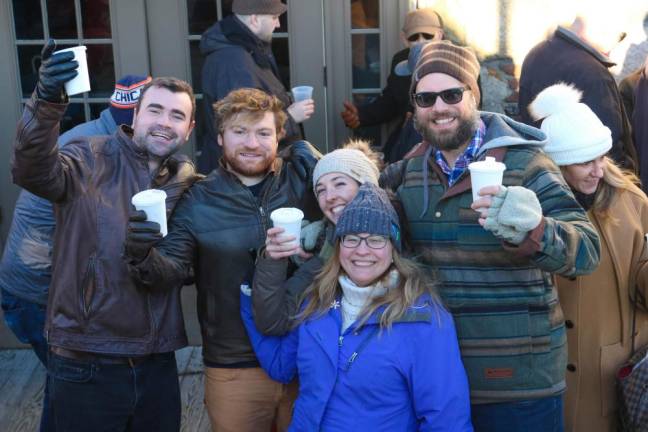 Friends Toast with paper cups at the Lake Mohawk German Christmas Market.
