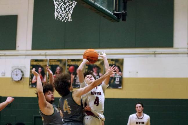 Newton's Ayden Babakissina (4) takes the ball toward the hoop.