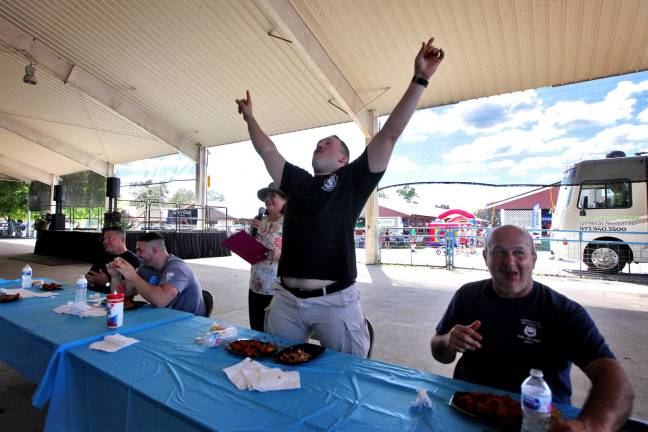 Sparta Police Officer Taylor May rejoices in his chicken wing eating contest win at Sussex County Day 2018.